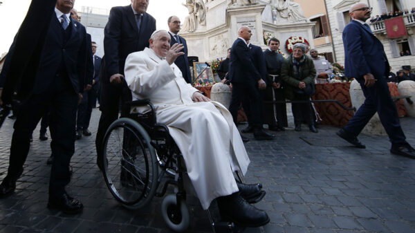 Pope Francis greets the crowd from a wheelchair after praying in front of a Marian statue at the Spanish Steps in Rome Dec. 8, 2022, the feast of the Immaculate Conception.