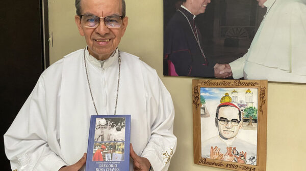 Cardinal Gregorio Rosa Chávez holding a copy of his book on Oscar Romero.