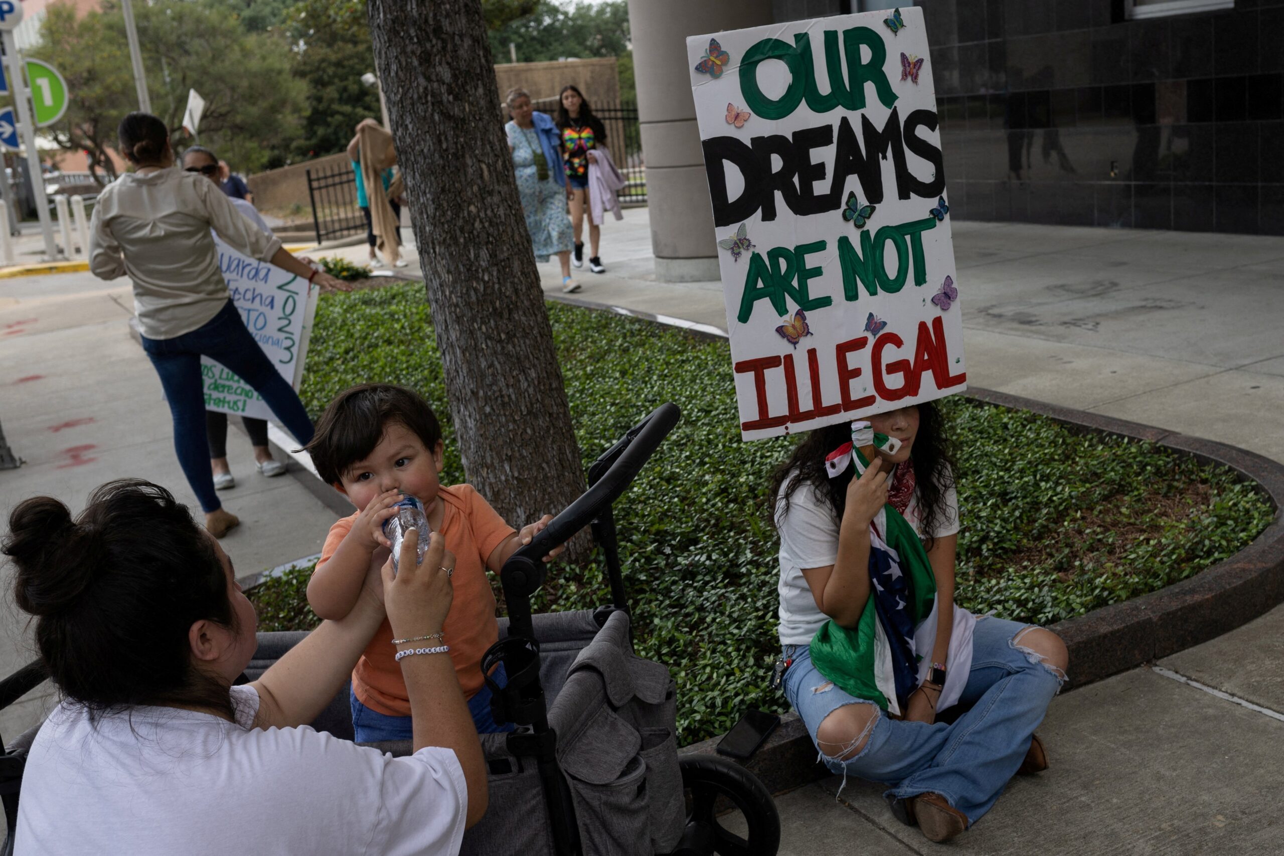 Deferred Action for Childhood Arrivals policy recipients Susana Lujano, 30, provides water to her one year old son Joaquin next to Brendaletzy Lopez, 30, who holds a placard ahead of a hearing on the DACA program outside the federal courthouse in Houston, Texas, U.S., June 1, 2023. A federal judge in Texas ruled Sept. 13 that Biden's version of DACA is illegal but keeps the program in place for current immigrant recipients. (OSV News photo/Adrees Latif, Reuters file photo)