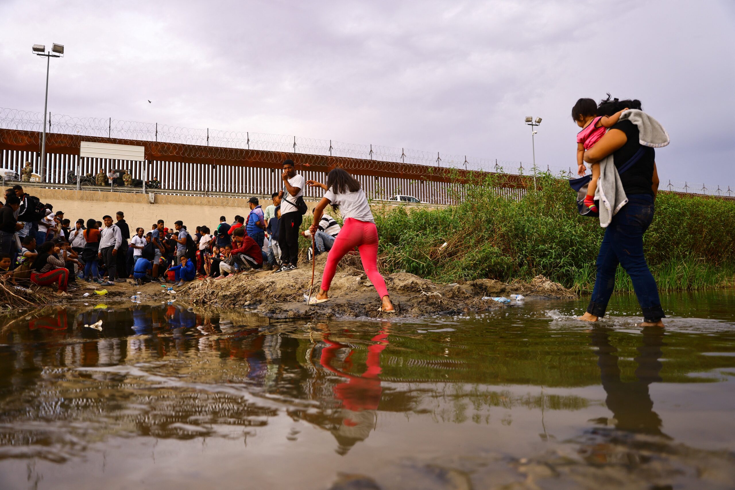 Migrants seeking asylum in the United States gather near a wire fence Sept. 12, 2023, as members of the Texas National Guard stand by to stop migrants from entering the United States after crossing the Rio Grande from Mexico. (OSV News photo/Jose Luis Gonzalez, Reuters)