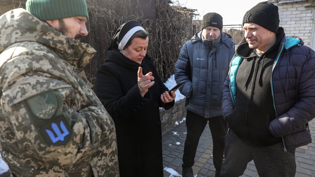 Basilian Sister Lucia Murashko talks with volunteers Denys Kuprikov, left, and Ivan Smyglia, far right, in Zaporizhzhia in southeast Ukraine Feb. 7, 2023, about where they will distribute humanitarian aid along the front in Russia's war against Ukraine. Catholic Extension, a Chicago-based nonprofit, announced Sept. 27 that it has named the Sisters of the Order of St. Basil the Great as the 2023-2024 recipients of its highest honor, the Lumen Christi Award. (OSV News photo/Konstantin Chernichkin, CNEWA)