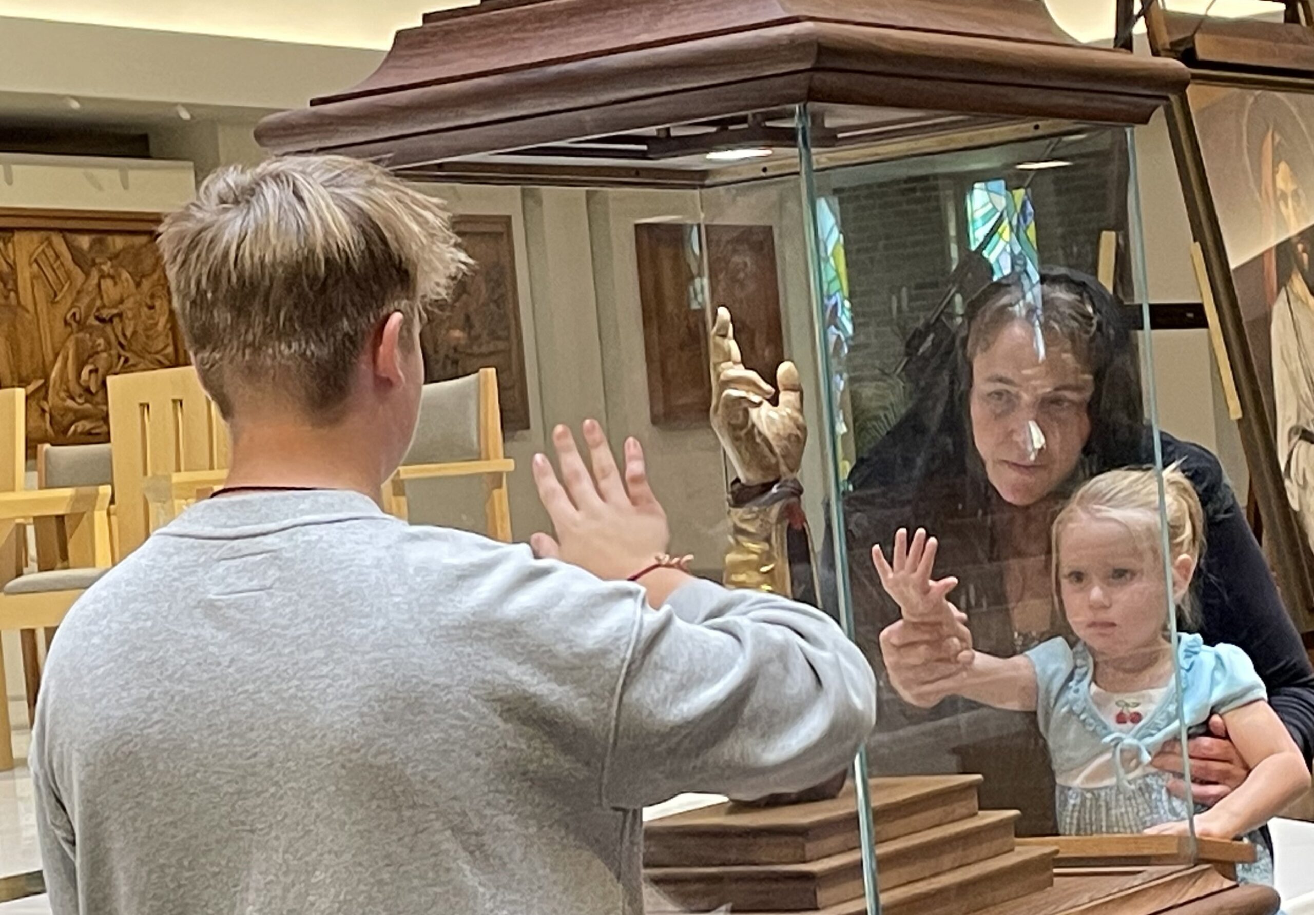 Jennifer Bradac, a parishioner of All Saints Parish in Minneapolis, venerates a relic of St. Jude with her granddaughter Ellie, right, and son Benjamin Sept. 29, 2023, at St. Joseph Parish in West St. Paul, Minn. (OSV News photo/Maria Wiering)