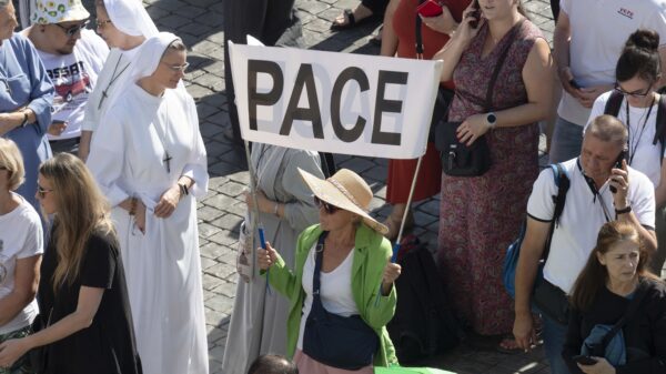 Una mujer sostiene un cartel que dice "Pace", paz en italiano, mientras el Papa Francisco pide el fin de la violencia entre Israel y Palestina después de recitar la oración del Ángelus el 8 de octubre de 2023, con los visitantes en la Plaza de San Pedro en el Vaticano. (Foto CNS/Vatican Media)