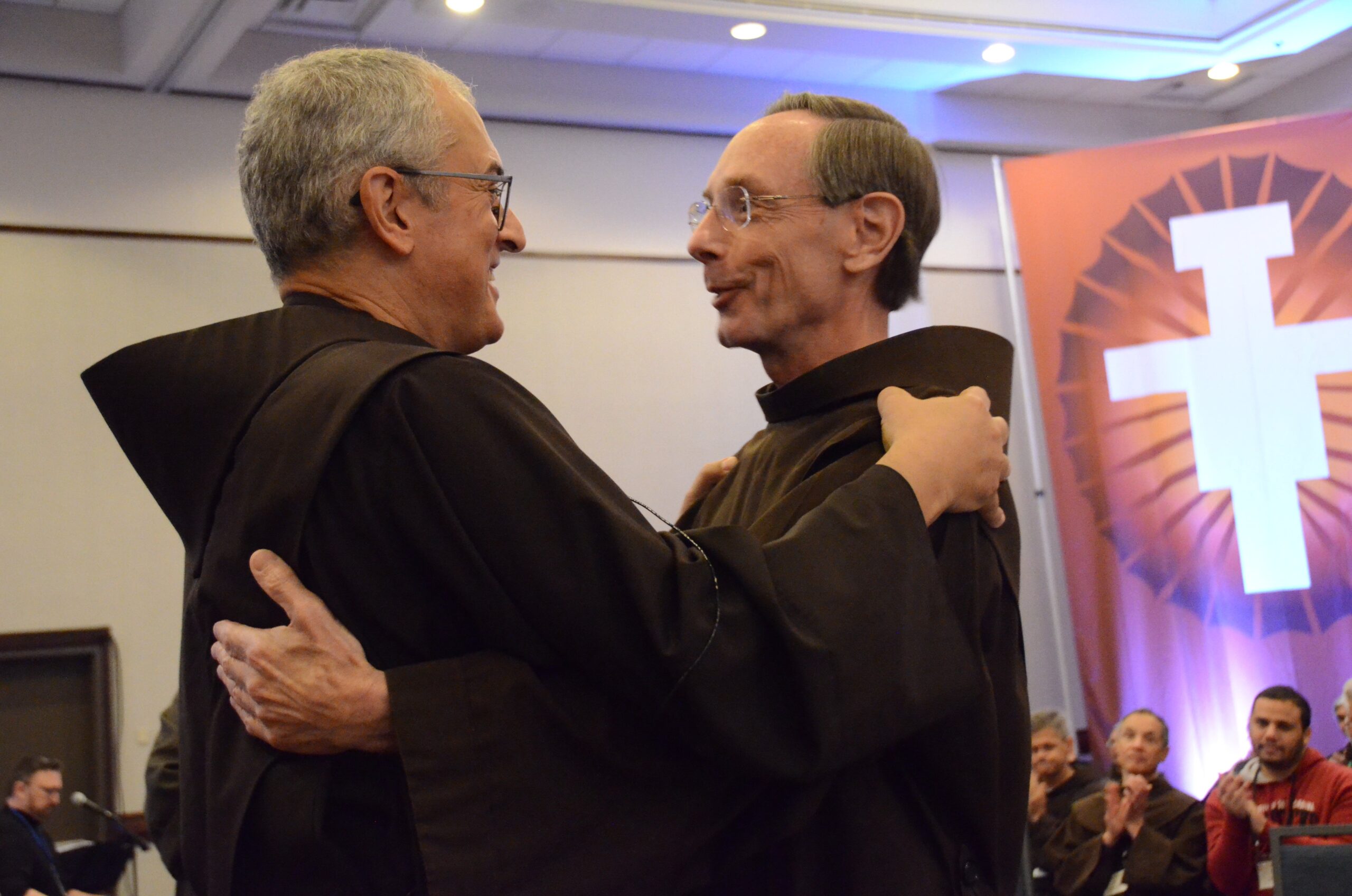 Franciscan Brothers Massimo Fusarelli, minister general of the Order of Friars Minor, and Lawrence Hayes,embrace after Brother Hayes was installed as provincial minister at the newly unified Province of Our Lady of Guadalupe Oct. 17, 2023, during a meeting in Kansas City, Mo. The new province, based in Atlanta, unifies six legacy provinces, which were established over the long history of the Order of Friars Minor in the United States. (OSV News photo/Octavio Duran)