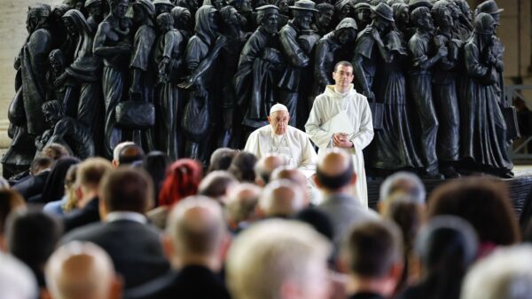 Pope Francis shares a moment of silence with members of the assembly of the Synod of Bishops at the end of a prayer for migrants and refugees in St. Peter's Square at the Vatican Oct. 19, 2023. The service took place around "Angels Unawares," a sculpture by Canadian Timothy Schmalz, depicting a boat with 140 figures of migrants from various historical periods and various nations. (CNS photo/Lola Gomez)