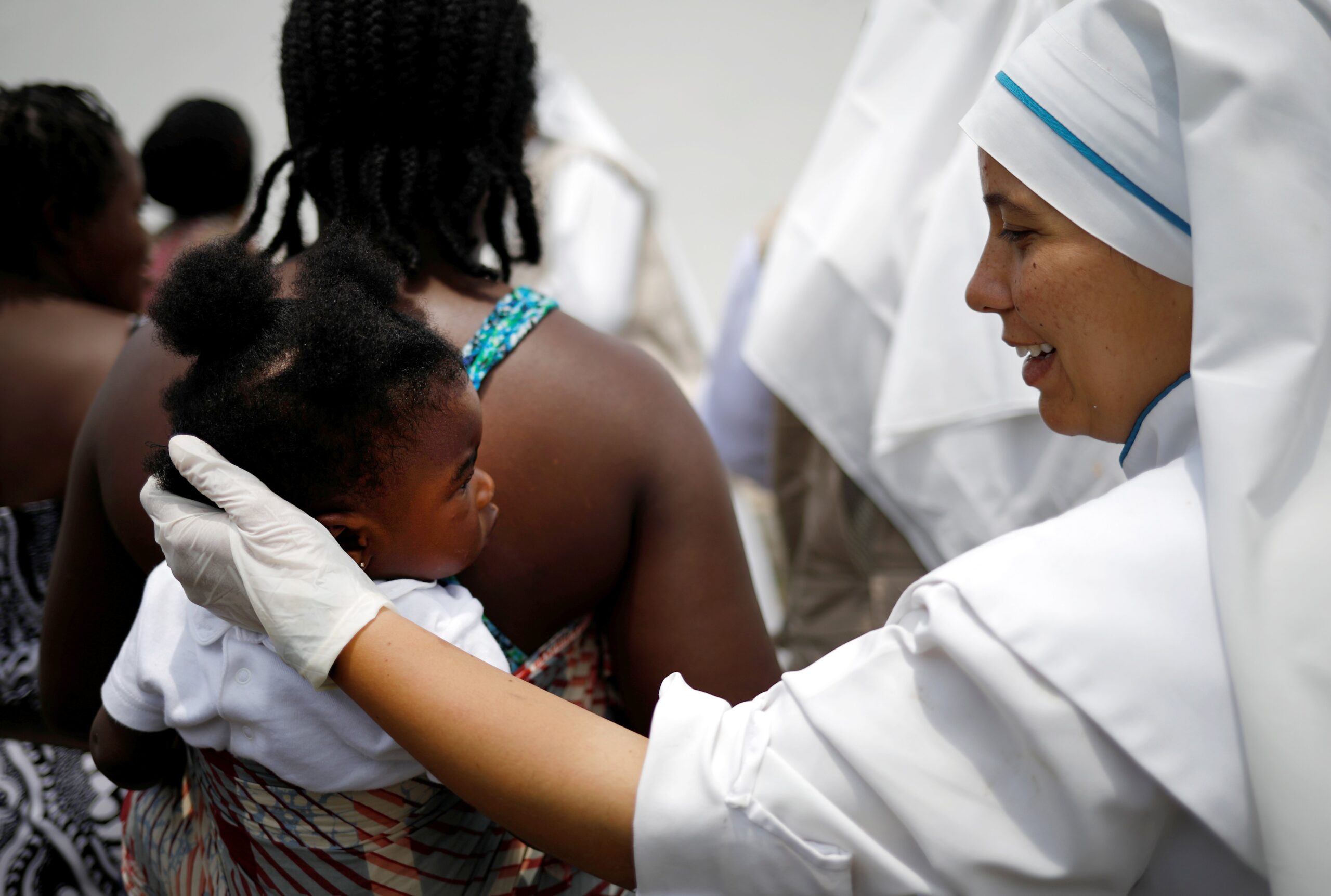 A member of the Missionaries of the Risen Christ comforts a young migrant in Tapachula, Mexico, May 11, 2019. Priests and parishioners in the U.S. Archdiocese of Boston must be "ready and willing to assist" the historic influx of migrants entering Massachusetts, Boston Cardinal Seán P. O’Malley wrote in a letter to parishes Oct. 23, 2023. (OSV News photo/Andres Martinez Casares, Reuters)