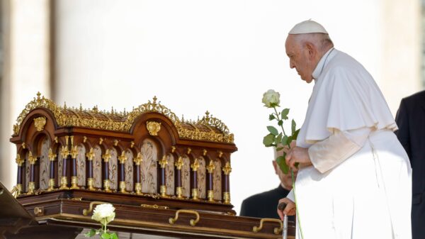 Pope Francis carries a white rose as he approaches a reliquary containing the relics of St. Thérèse of Lisieux before the start of his general audience in St. Peter's Square at the Vatican June 7, 2023. The pope issued an apostolic letter Oct. 15 that was dedicated to the saint for the 150th anniversary of her birth. (CNS photo/Lola Gomez)