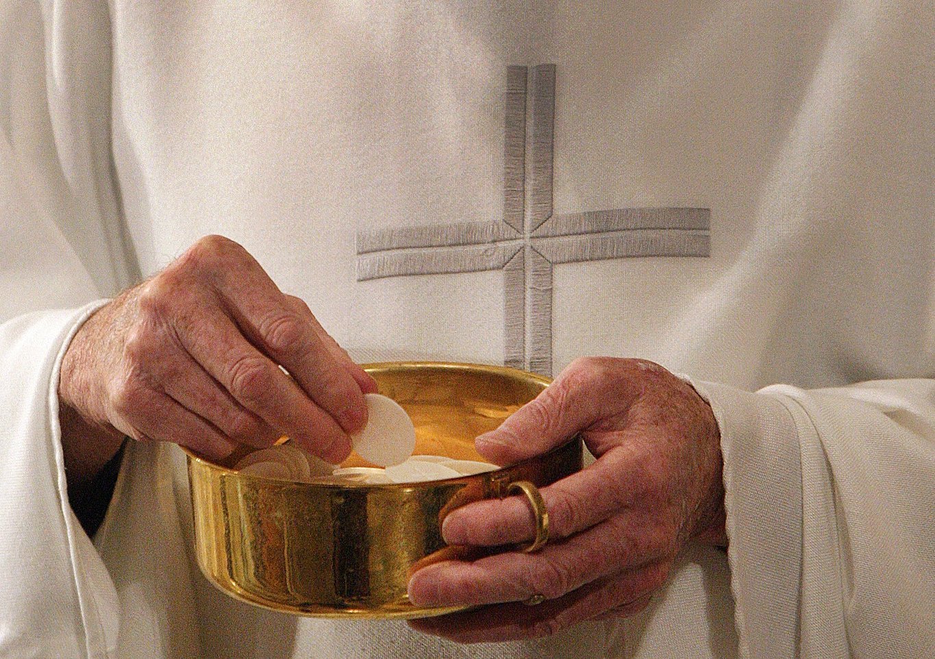This is an illustration of a priest distributing Communion. The Diocese of Stockton, Calif., has issued a warning about impostors posing as Catholic clergy and charging Spanish-speaking faithful "exorbitant fees" for celebrating the sacraments. (OSV News photo/Bob Roller)