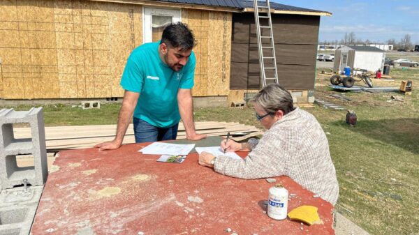Khaibar Shafaq, a paralegal and case manager for Catholic Charities of the Diocese of Owensboro, Ky., works with Sheila Rose at the construction site of her home rebuild in Dawson Springs, Ky., March 15, 2022. Rose's home was destroyed by a tornado Dec. 10, 2021. (CNS photo/courtesy Susan Montalvo-Gesser)