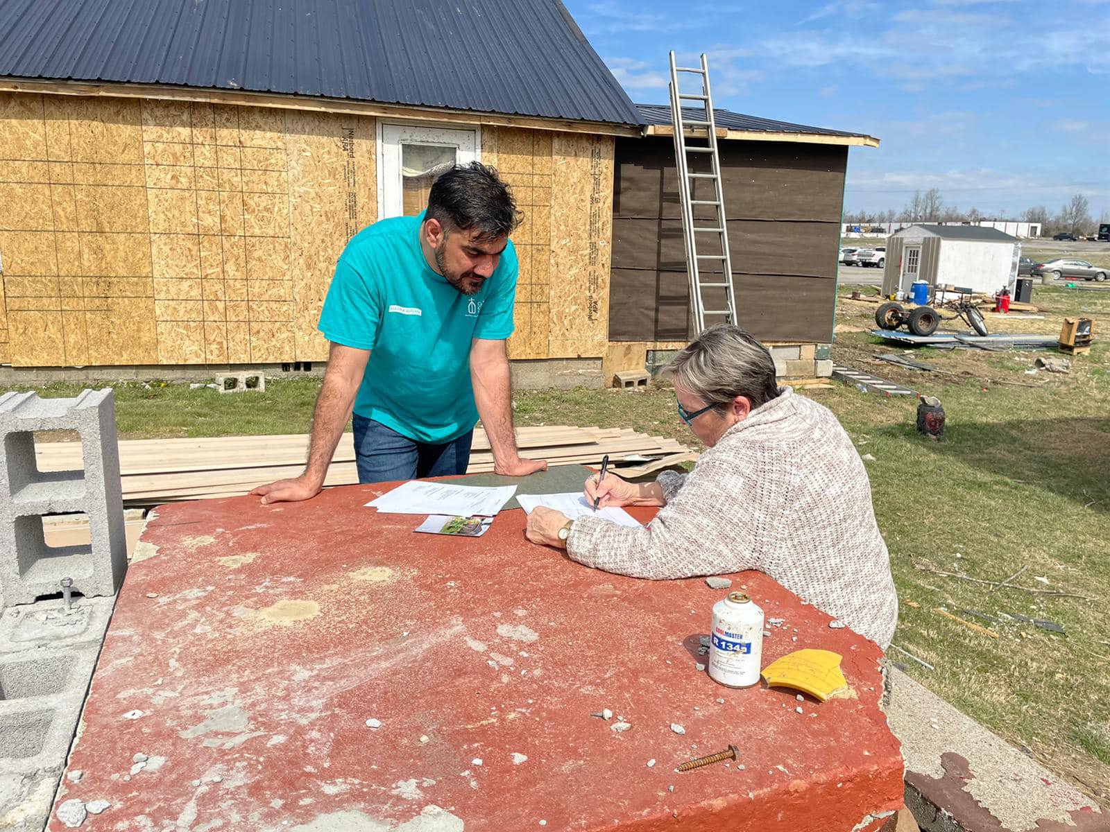 Khaibar Shafaq, a paralegal and case manager for Catholic Charities of the Diocese of Owensboro, Ky., works with Sheila Rose at the construction site of her home rebuild in Dawson Springs, Ky., March 15, 2022. Rose's home was destroyed by a tornado Dec. 10, 2021. (CNS photo/courtesy Susan Montalvo-Gesser)