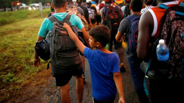 A young migrant from Venezuela walks with his brother as they join a caravan near Villa Comaltitlán, Mexico, heading to the U.S. border Nov. 20, 2021. (CNS photo/Jose Luis Gonzalez, Reuters)