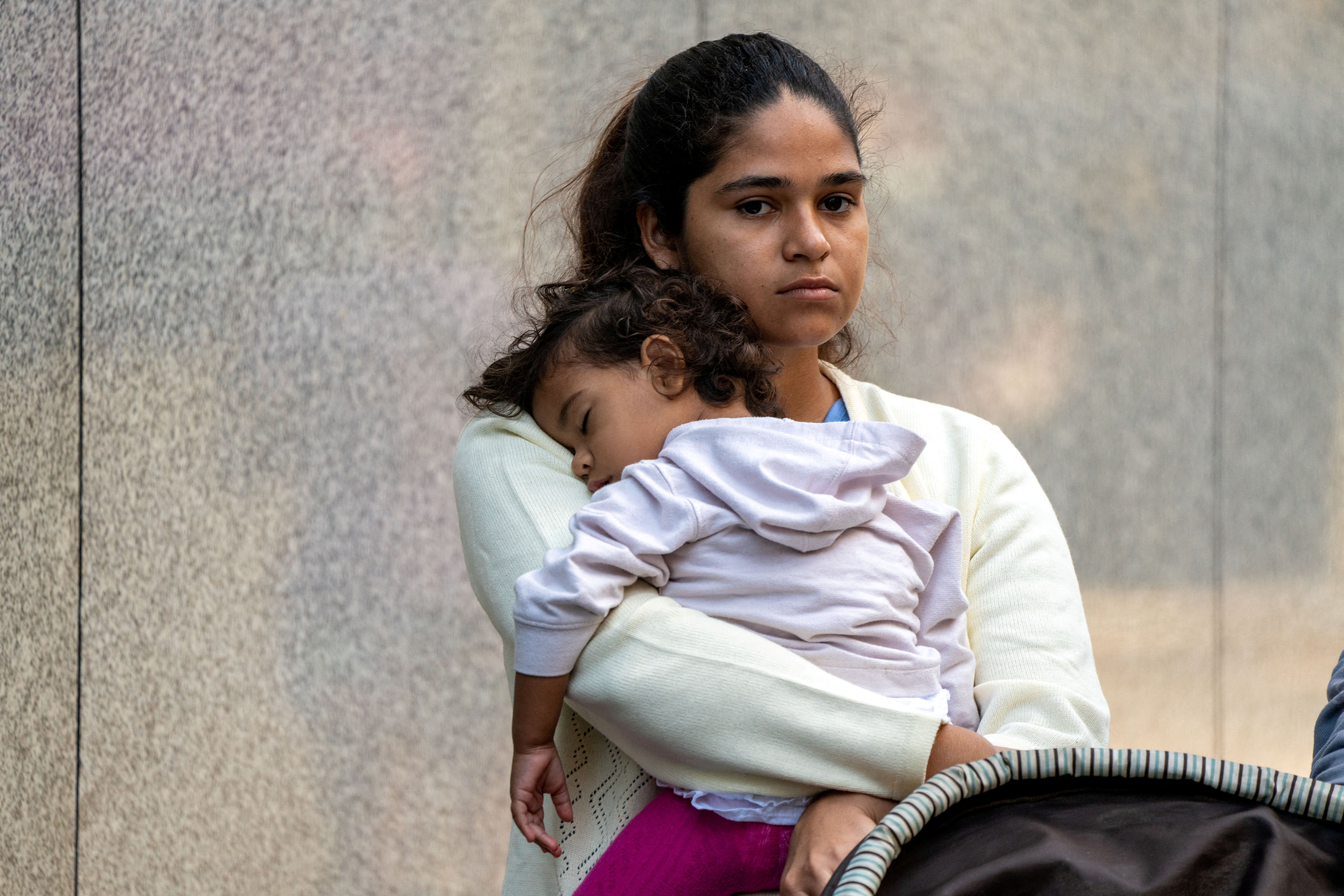 A migrant and her daughter wait for aid outside the offices of Catholic Charities Aug. 16, 2022, after being transported via charter bus from Texas. Catholic Charities USA responded Oct. 31, 2023, to "disturbing" recent remarks by a social media influencer threatening its staff for assisting migrants with basic humanitarian needs after they have been released into the country by federal authorities. (OSV News photo/David Delgado, Reuters)