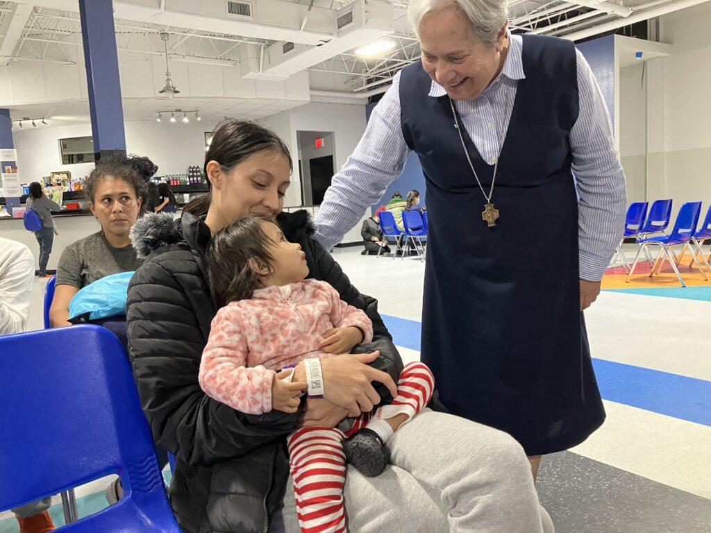 Sister Norma Pimentel, a Missionary of Jesus, greets Esther Chicas, a recently arrived migrant from El Salvador, and her child, Andrea, at the Humanitarian Respite Center in McAllen, Texas on Nov. 11, 2023. Sister Norma has urged Catholics to "defend life" through projects such as Catholic Charities' work with the migrant population, especially at the border. (OSV News/David Agren)