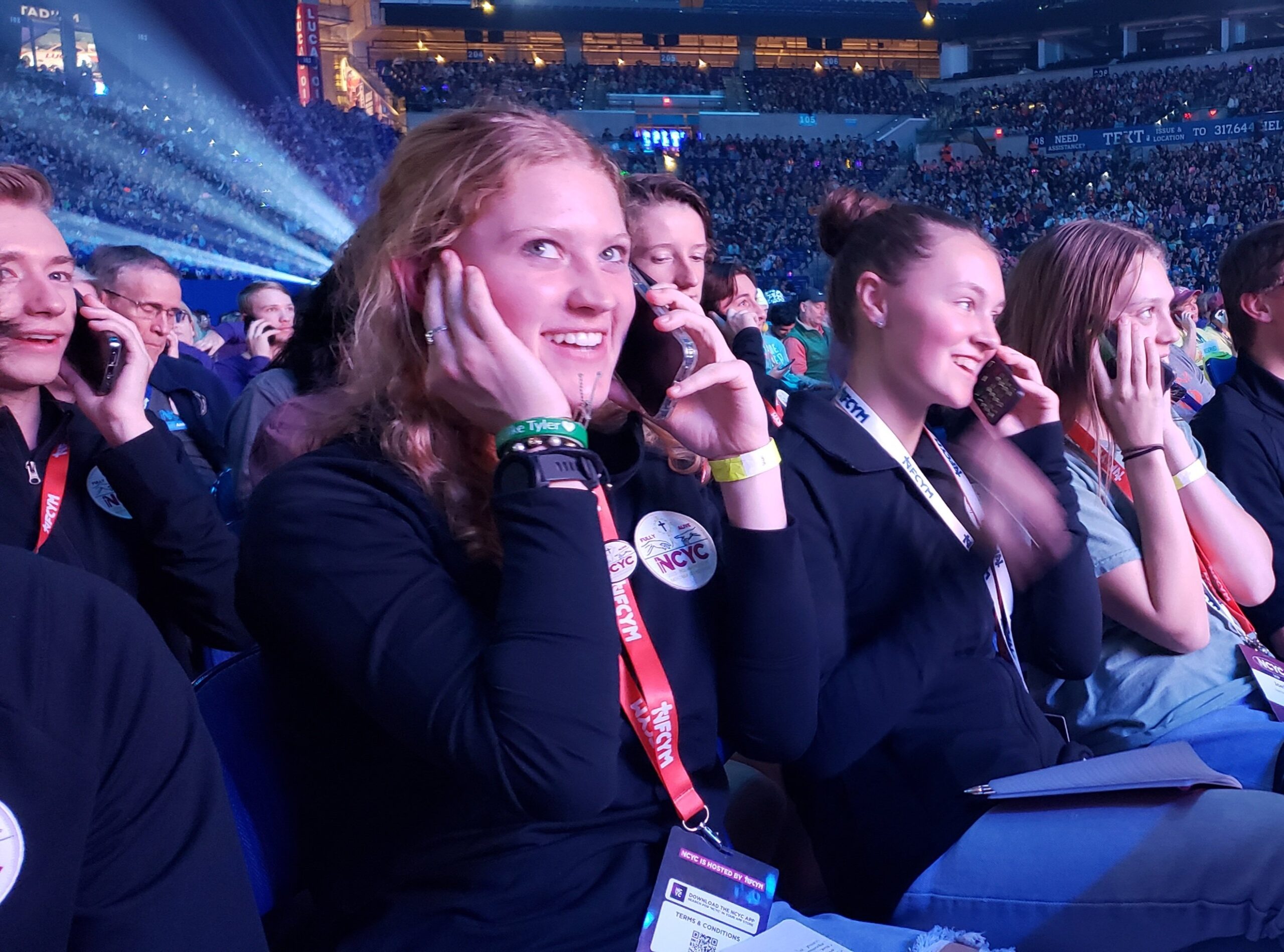 Grace Stacker of the Diocese of Helena, Mont., and those around her call a loved one (for Grace, her dad), as an exercise during the opening session of the National Catholic Youth Conference in Lucas Oil Stadium in Indianapolis on Nov. 16. (OSV News photo/Natalie Hoefer, The Criterion)