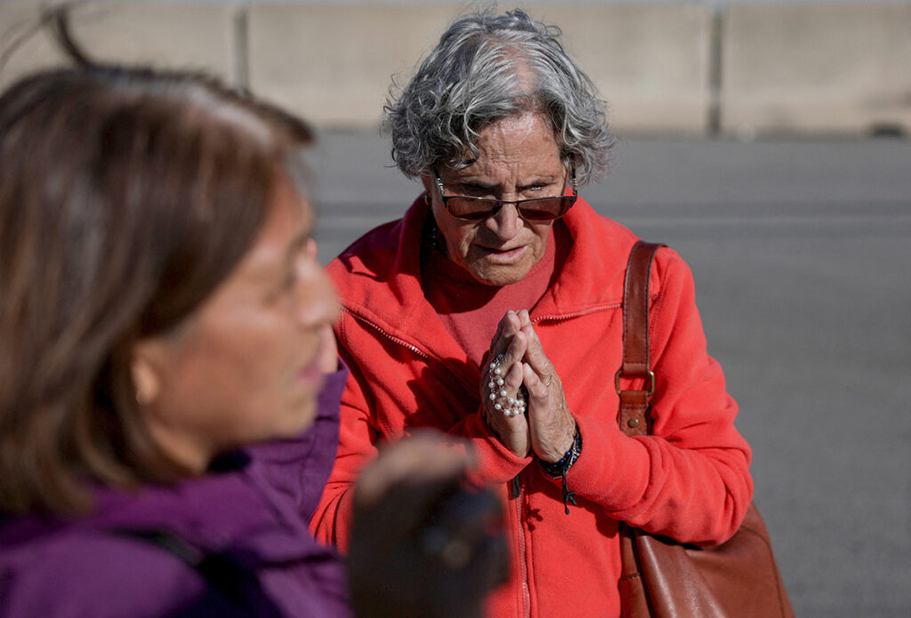 A woman prays with a rosary outside the U.S. Immigration and Customs Enforcement (ICE) Broadview facility in Chicago Oct. 9, 2025. (OSV News photo/Jeenah Moon, Reuters)