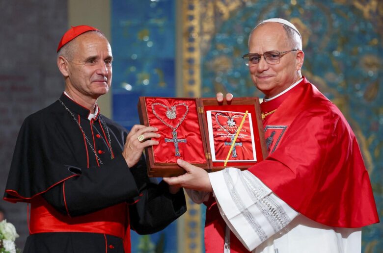 Pope Leo XIV receives a gift from Cardinal Jean-Paul Vesco of Algiers, Algeria, as he attends a meeting with the Algerian community at the Basilica of Our Lady of Africa in Algiers April 13, 2026. (OSV News photo/Guglielmo Mangiapane, Reuters)