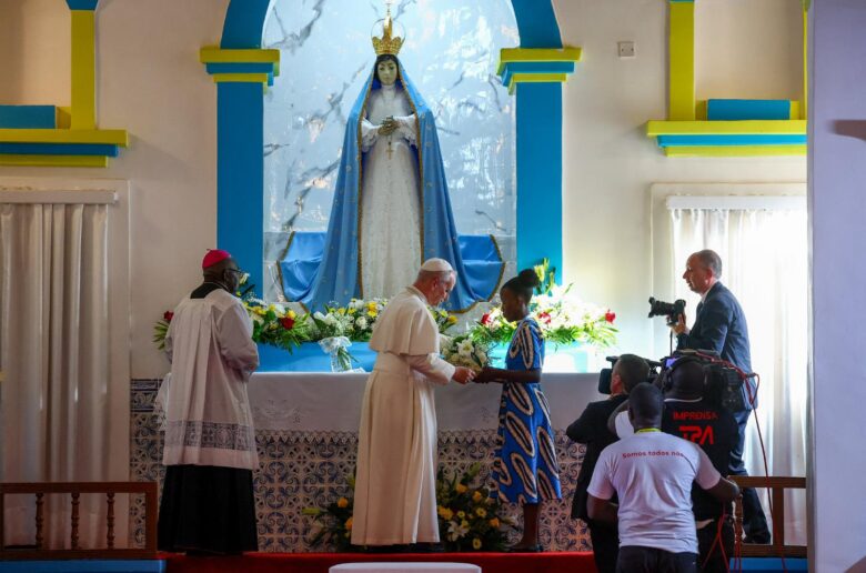 Pope Leo XIV receives flowers to be put under the statue of Mary inside the Sanctuary of Our Lady of Muxima, during his apostolic journey in Africa, in Muxima, Angola, April 19, 2026. (OSV News photo/Guglielmo Mangiapane, Reuters)