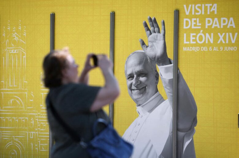 A woman in Madrid takes a picture of a poster of Pope Leo XIV May 28, 2026, ahead of the pontiff's June 6-12 apostolic visit to Spain. (OSV News photo/Kacper Pempel, Reuters)