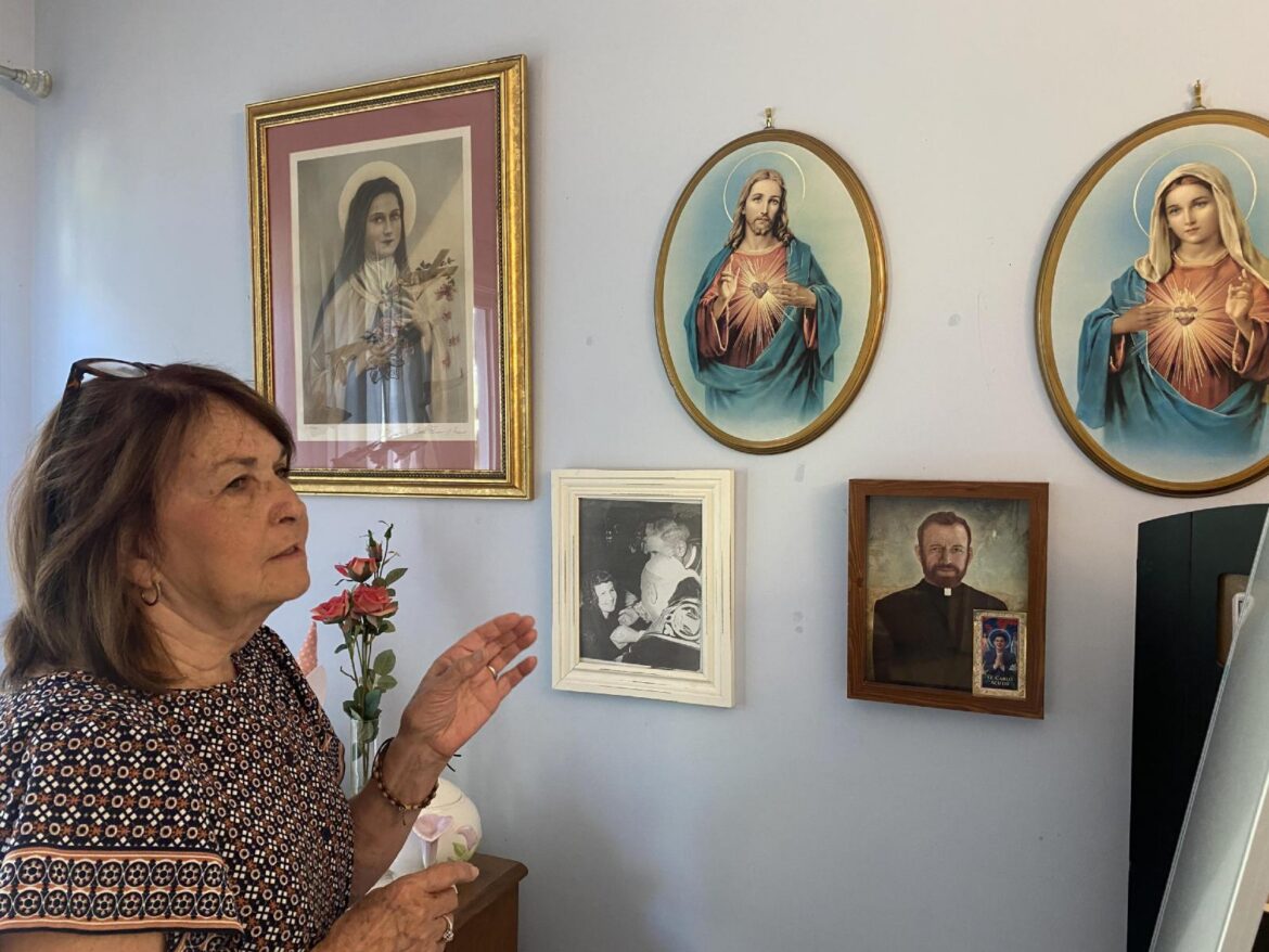 Ann Teresa O'Neill shares with a visitor the meaning of religious images that fill her home in Easton, Md., in this undated photo. O’Neill, whose confirmed miraculous cure from acute lymphatic leukemia as a child led to the canonization of St. Elizabeth Ann Seton, died July 17, 2026, at her home in Easton. She was 78.(OSV News photo/Connie Connolly, The Dialog)