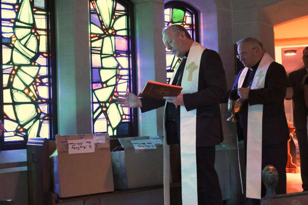 Irish Archbishop Eamon Martin of Armagh blesses Venerable Father Edward Flanagan medals with Archbishop Michael G. McGovern of Omaha, Neb., near the tomb of the Omaha priest and founder of Boys Town at Dowd Memorial Chapel of the Immaculate Conception in Omaha July 16, 2026. The parish serves the village of Boys Town. (OSV News photo/Riley Johnson, The Catholic Voice)