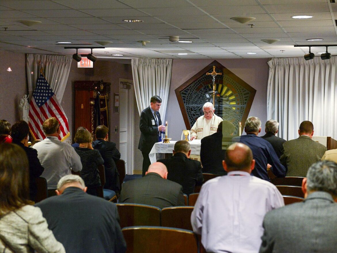 Father John Davis celebrates Mass assisted by a volunteer at the Pentagon Memorial Chapel in Arlington, Va., during the National Day of Prayer May 5, 2016. The chapel, attack, opened on the first anniversary of the 9/11 terrorist attack on the Pentagon, built directly at the impact site where the hijacked plane crashed into the Pentagon. (OSV News photo/Dave Vergun, courtesy DOD)