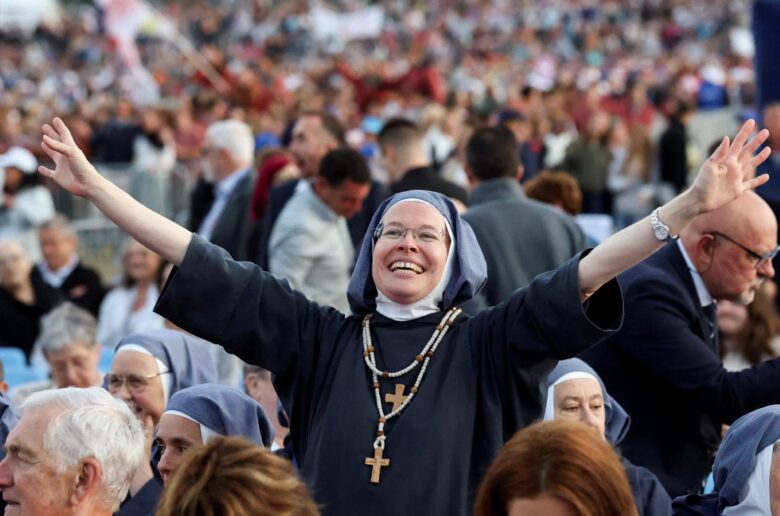 A religious sister reacts as faithful wait for the arrival of Pope Leo XIV to celebrate a Sunday Mass on the prairie at the Sanctuary of Our Lady of Lourdes, as part of his four-day apostolic journey to France, in Lourdes, France, Sept. 27, 2026. (OSV News photo/Stephane Mahe, Reuters)
