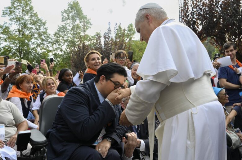 Theo-Joseph Stelletta, who at age 24 suffered from paralysis and now serves as a cantor and hospitaller helping the sick at the Sanctuary of Lourdes, kisses the hand of Pope Leo XIV during the pope’s four-day apostolic journey in France, in Lourdes, France, Sept. 27, 2026. (OSV News photo/Simone Risoluti, Vatican Media)