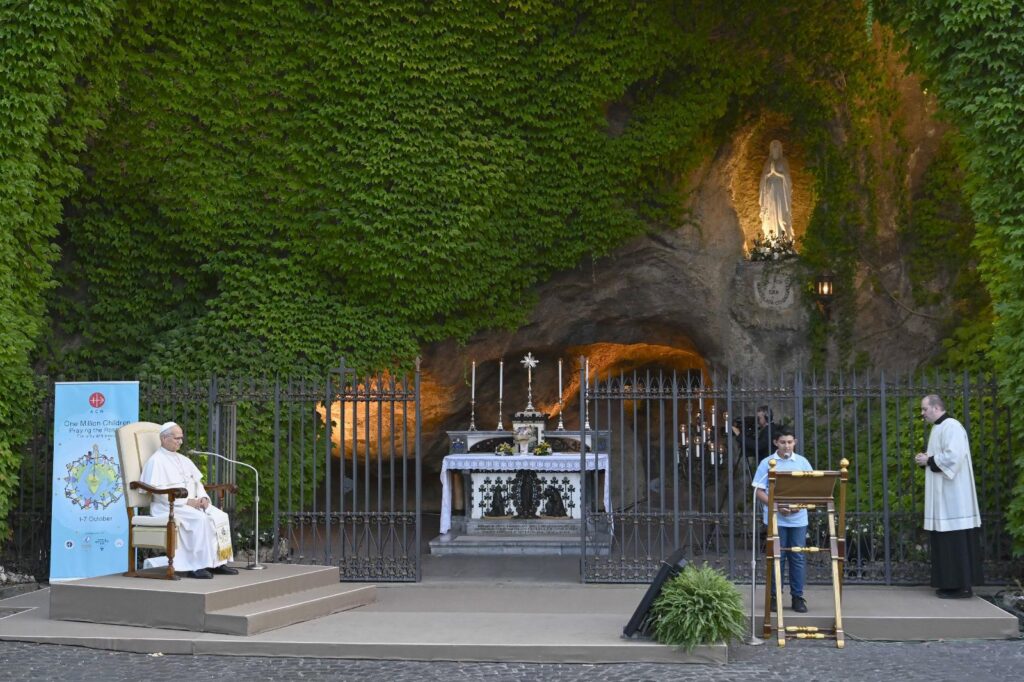 A youth leads the prayer of a mystery of the rosary as Pope Leo XIV and hundreds of children join in praying the rosary for peace in the Lourdes Grotto in the Vatican Gardens on the evening of Oct. 1, 2026, the month dedicated to the prayer of the rosary. (OSV News photo/Simone Risoluti, Vatican Media)