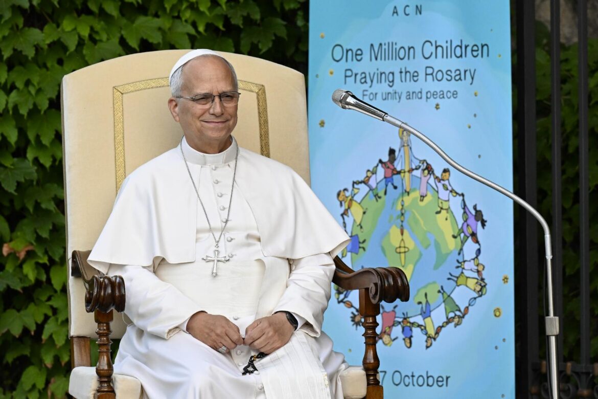 Pope Leo XIV smiles as he is joined by hundreds of children as he prays the rosary for peace in the Lourdes Grotto in the Vatican Gardens on the evening of Oct. 1, 2026, the month dedicated to the prayer of the rosary. (OSV News photo/Matteo Pernaselci, Vatican Media)