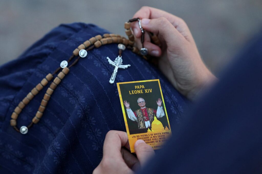 A woman prays with a rosary and a card portraying Pope Leo XIV Oct. 14, 2026, where Pope Leo XIV had surgery the previous evening to remove a lung nodule. The Vatican confirmed after the surgery that Pope Leo has lung cancer. (OSV News photo/Yara Nardi, Reuters)