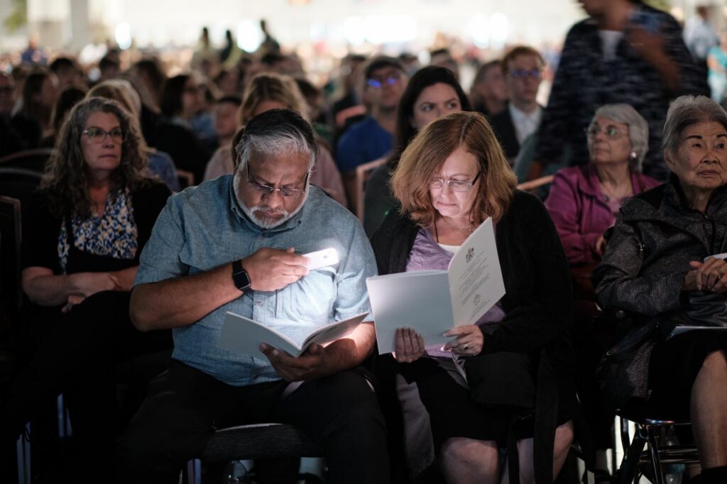 Attendees look at the program during the beatification Mass for the five Georgia Martyrs Oct. 31, 2026, at the Savannah Convention Center on Hutchinson Island in Savannah, Ga. The martyred Spanish Franciscan missionaries, who were killed at their Georgia missions in 1597, were Fathers Pedro de Corpa, Blas Rodríguez de Cuacos, Miguel de Añon, and Francisco de Veráscola and Brother Antonio de Badajoz. (OSV News photo/George Martell)e Martell)